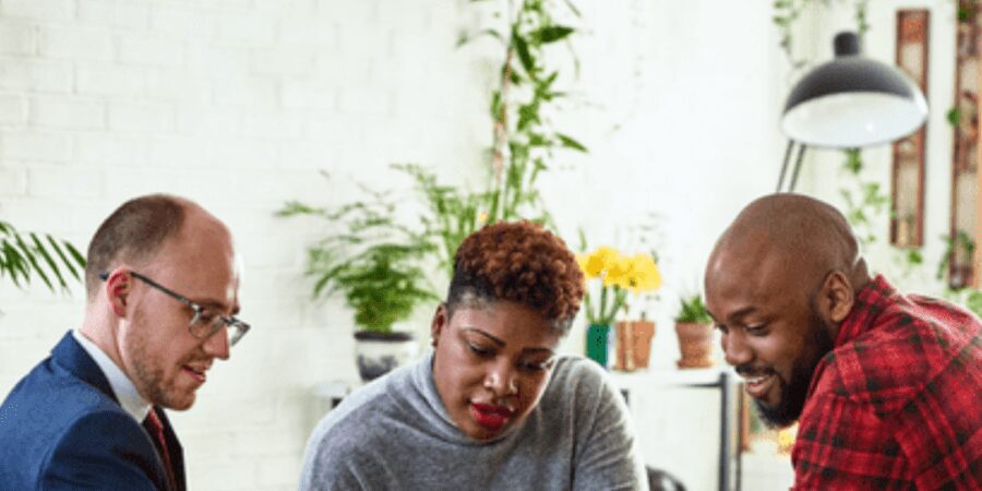 Three people collaborating in a meeting room.